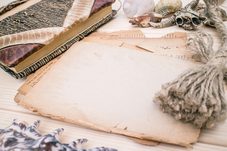 Vintage style rustical mockup with an old blank paper on a wooden texture, amulets, notebook, seashells. Copy space. Place for textの写真素材
