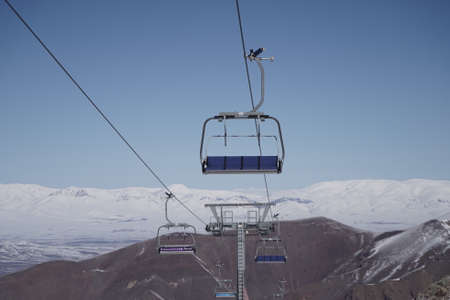 Empty Chairlifts in Ski Resort and Snowy Mountain in Backgroundの写真素材