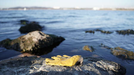 Plastic Gloves Throw on the Rocks by the Seaの写真素材