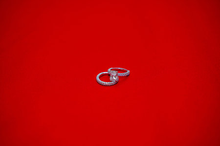 Diamond engagement ring on red background.