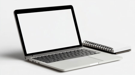 a laptop with a blank screen next to a notebook on a white background in a studio setting close up viewの素材