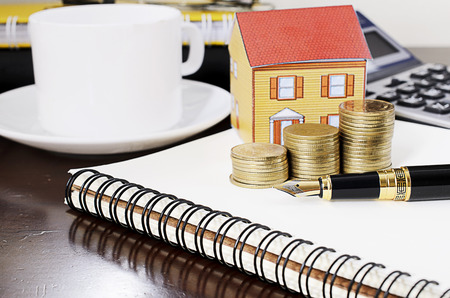 business fountain pen with coins stack and paper  home on notepad for home repair loans conceptの写真素材