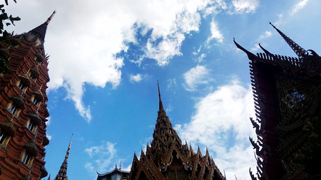 Thai temple roof with blue sky cloudy backgroundsの写真素材