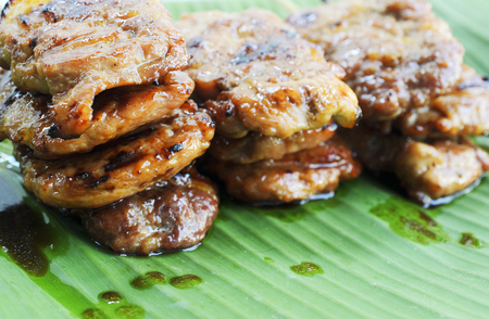 Close up of Delicious grilled pork mooping thai local food on banana green leafの写真素材