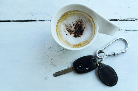 cup of coffee and car key on wooden table backgrounds aboveの写真素材