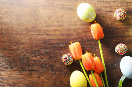 Easter festival concept with fancy eggs and tulips flower on wooden table backgrounds above