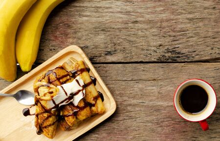 Banana French toast with chocolate dripping syrup and Red coffee cup, Place for your textの写真素材
