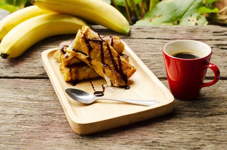 Banana French toast with chocolate dripping syrup and hot coffee cupの写真素材
