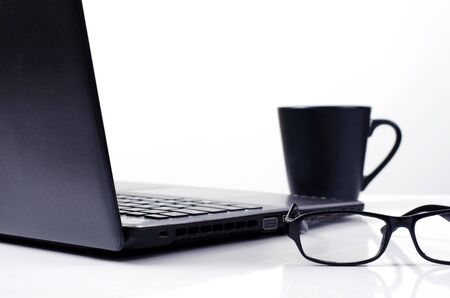 Close up of eyeglasses with labtop computer and coffee cups on white backgrounds for Life style...