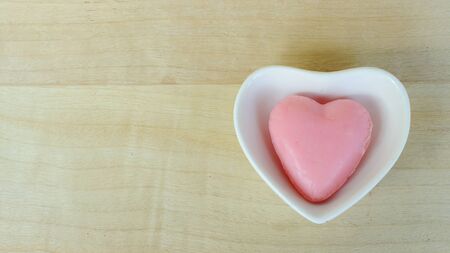 Heart soap in blow heart shaped on wooden table backgrounds above. Top viewsの写真素材