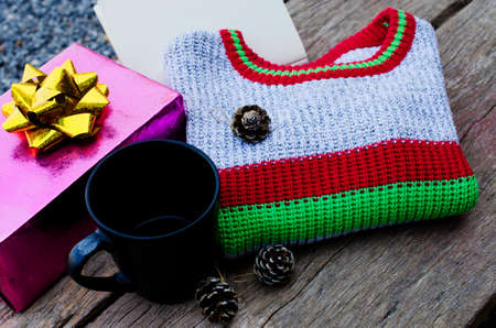 Still life of Knitting sweater and black cup on old wooden backgrounds for Christmas and happy new year conceptの写真素材