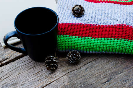 Still life of Knitting sweater and black cup on old wooden backgrounds for Christmas and happy new year conceptの写真素材