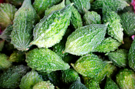 Close up of green bitter gourd vegetable raw food on vintage wood table backgrounds conceptの写真素材