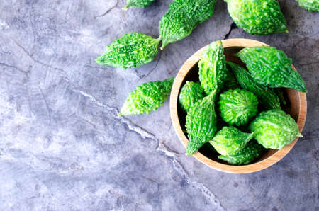 Close up of green bitter gourd vegetable raw food on vintage wood table backgrounds concept