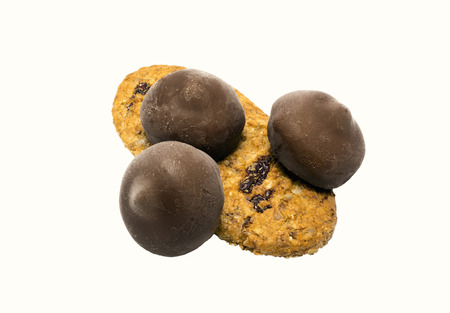 beautiful cookies in the company of three chocolates on a white backgroundの写真素材