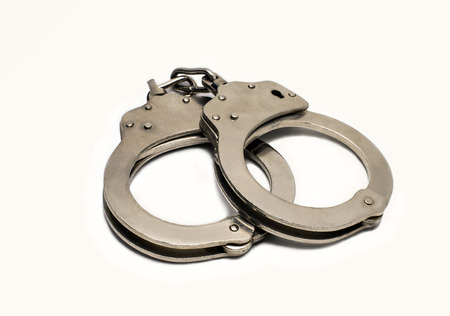 steel handcuffs lying on a white backgroundの写真素材