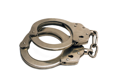 steel handcuffs lying on a white backgroundの写真素材