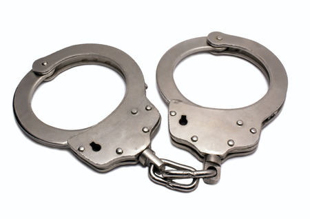 Steel police handcuffs lying on the gray backgroundの写真素材
