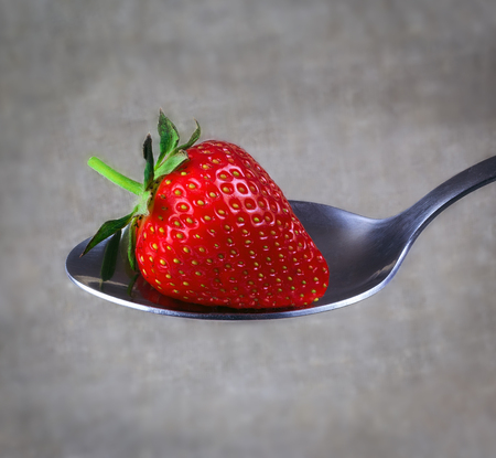 perfect ripe strawberry in a small spoon closeupの写真素材