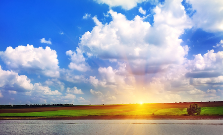 sunrise in the green field with blue clouds Desktopの写真素材