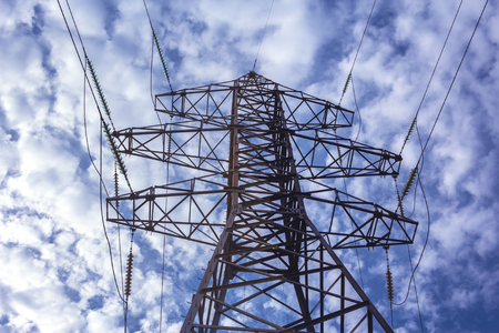 High-voltage line with electric pylons on the background of magnificent cloudsの写真素材
