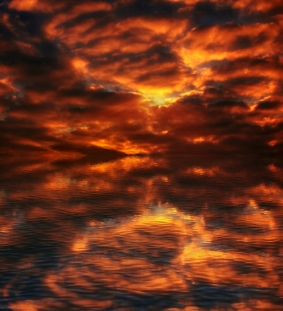 great fiery sunset over the ocean, with reflection in the wavesの写真素材