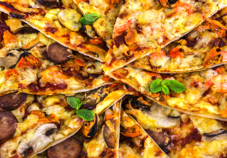 freshly baked pizza with salami, mussels and shrimp, fried chunks close-upの写真素材