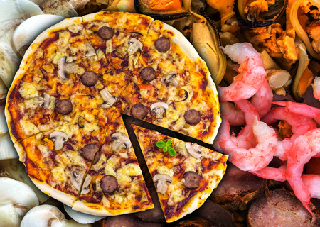 pepperoni pizza with salami on a background of mussels, shrimp, mushrooms and salami slicingの写真素材