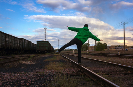 man travels on rails, against the background of beautiful clouds.の写真素材