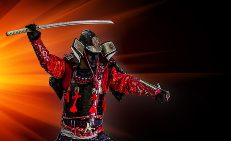 Samurai in ancient armor, with a sword ready to attack at sunset.の写真素材