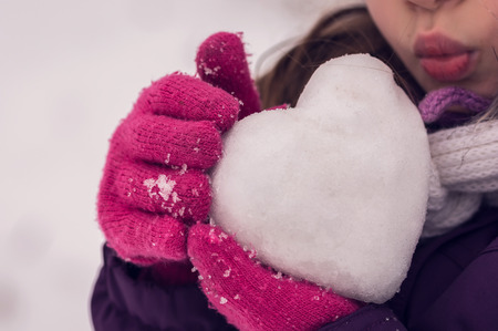 Girl neatly kisses the icy heart. Happy Valentine's day.の写真素材