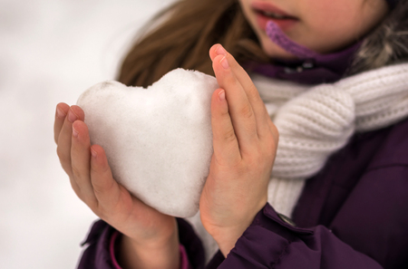 Girl holds neatly icy heart. Happy Valentine's day.の写真素材