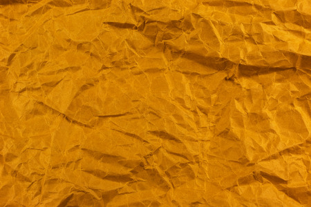 Crumpled paper background vignette. texture of crumpled  gold paper.の写真素材