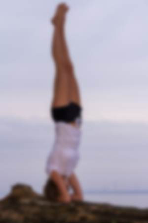 Silhouette of a girl yoga on the beach. Motivation blured background.の写真素材