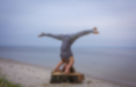 young woman practicing yoga on the beach .Athlete gymnast on a blurred background. 