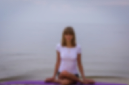 Silhouette of a girl yoga on the beach. Athlete gymnast . Motivation blured  background.の写真素材