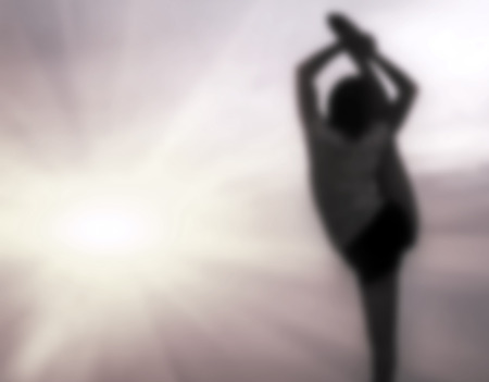  young woman practicing yoga on the beach at sunsetの写真素材