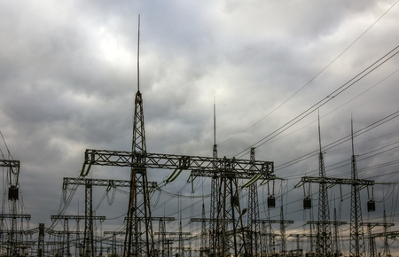 high-voltage  power lines at storm clouds. electricity distribution station. high voltage electric transmission tower.の写真素材