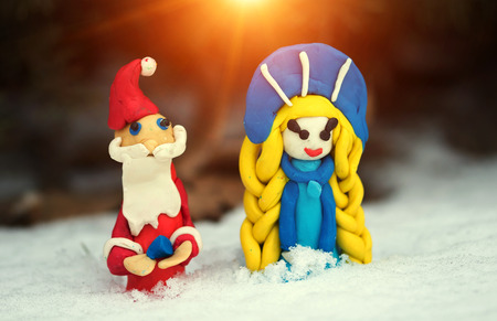 Christmas, New Year, Santa Claus and Snow Maiden in the snow at sunset.の写真素材