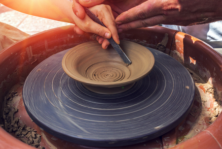 hand maid, molding from clay at sunset, making dishes with hands on the machine.の写真素材