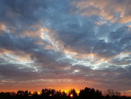 Fiery orange sunset colorful and speckled cloudsの写真素材