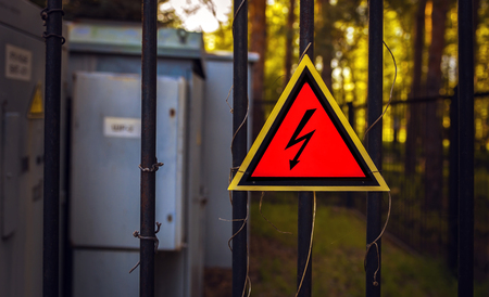 High voltage sign on a fence, on a background of transformers at sunset. top view.の写真素材