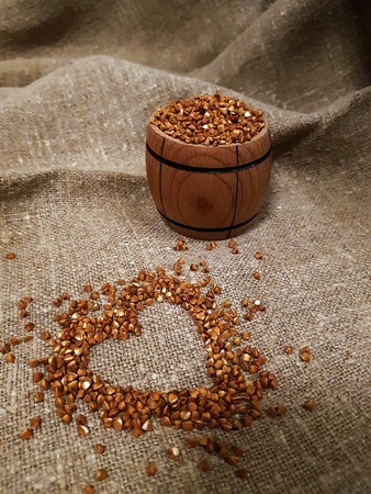 grains of buckwheat, drawing of a heart on burlap, rural background. Organic, diet food.の写真素材
