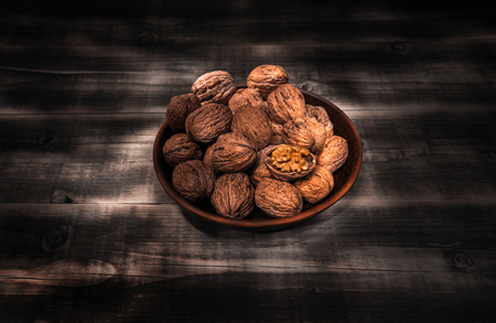 nuts, healthy nutritional food. walnut close-up in a clay bowl on a wooden background.の写真素材
