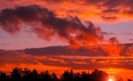 Fiery orange sunset colorful and speckled  clouds. Beautiful sky.の写真素材