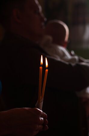 burning candle in his hand, a prayer in the church. The Christian faith.の写真素材