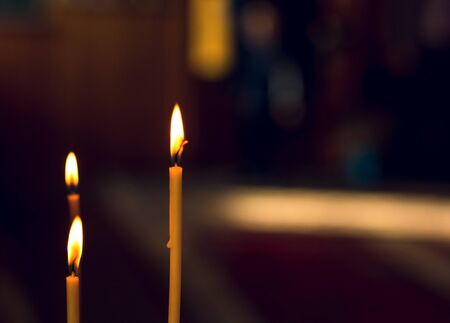 burning candle in his hand, a prayer in the church. The Christian faith.の写真素材