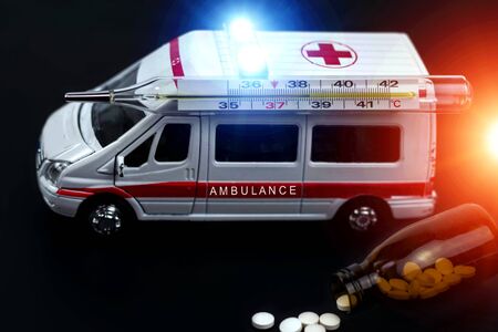  ambulance car with thermometer and pills on blured background. Ambulance auto paramedic emergency. の写真素材