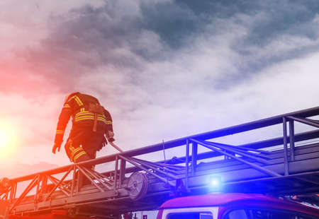 fireman extinguishes the fire at sunset with fire engine.