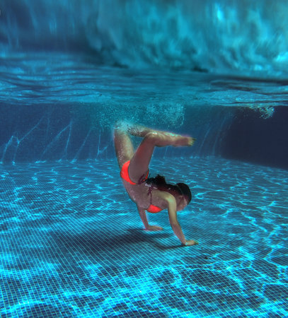 young girl in the pool underwater close-up. Summer background.の写真素材